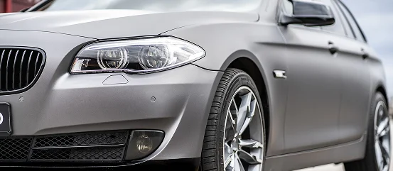 Alyans jantlar ve modern far tasarımıyla gümüş BMW sedanın ön yan detayı.